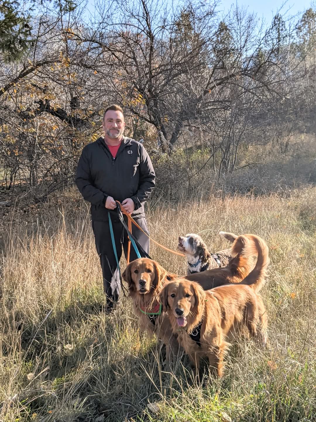 Scott Radford with three dogs on a trail